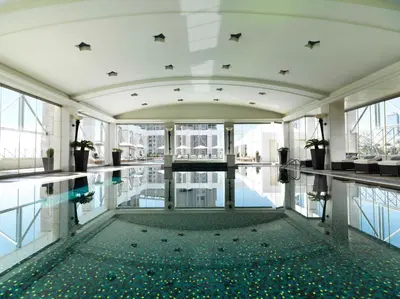a pool in the middle of a building with windows at Four Seasons Hotel Amman in Amman