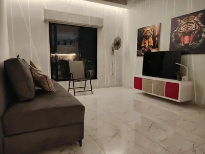 a living room with a couch and a flat screen tv at Abu alzoz home سكن مشترك in Amman