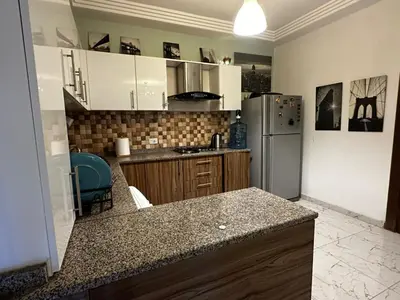 a kitchen with white cabinets and a stainless steel refrigerator at Abu alzoz home سكن مشترك in Amman