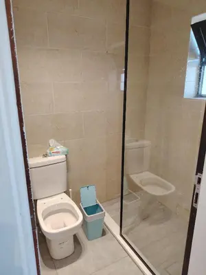 a small bathroom with a toilet and a shower at Abu alzoz home سكن مشترك in Amman