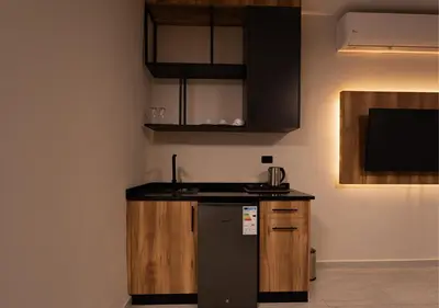 a kitchen with a refrigerator and a counter top at Al Jawhara Hotel Suites in Amman