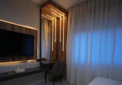 a hotel room with a television and a desk with a chair at Al Jawhara Hotel Suites in Amman