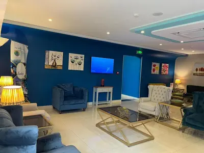 a living room with blue walls and blue furniture at Aquavista Hotel & Suites in Aqaba