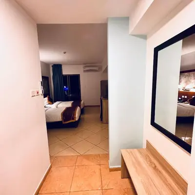 a hallway with a room with two beds and a mirror at Aquavista Hotel & Suites in Aqaba