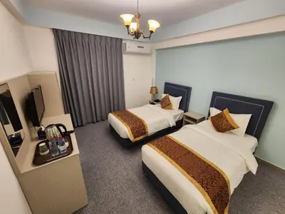a hotel room with two beds and a television at Aquavista Hotel & Suites in Aqaba