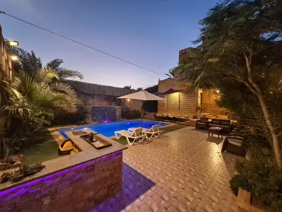 a backyard with a swimming pool and a house at Orient Villa-Dead Sea in Sowayma