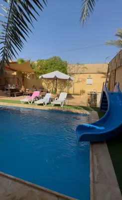 a swimming pool with a blue slide in a yard at Orient Villa-Dead Sea in Sowayma