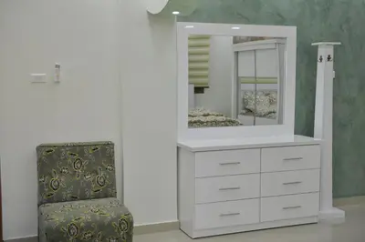 a white dresser with a mirror and a chair at Juniper House in Wadi Musa
