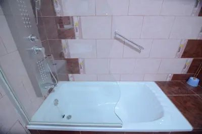 a shower with a white tub in a bathroom at Juniper House in Wadi Musa