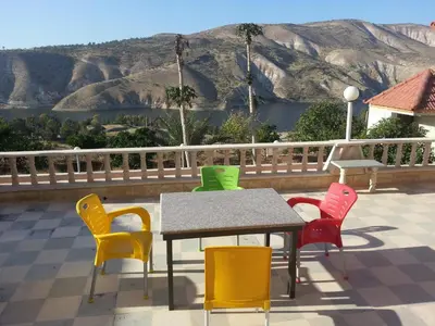 a table and chairs with a view of a mountain at Murshed Motel in Ash Shūnah ash Shamālīyah