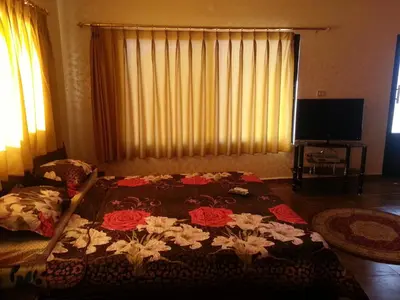 a bedroom with a bed with a blanket with flowers on it at Murshed Motel in Ash Shūnah ash Shamālīyah