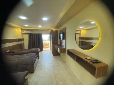 a living room with two beds and a mirror at Al Deyafa Hotel in Aqaba