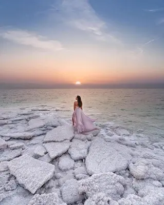 a woman sitting on the rocks in the water at Grand Hotel Madaba in Madaba