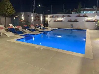 a large swimming pool with chairs and a blue pool at Grand Hotel Madaba in Madaba