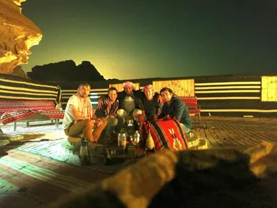 a group of people sitting around a table at WADI RUM-Bedouin Tents and Jeep Tours in Wadi Rum