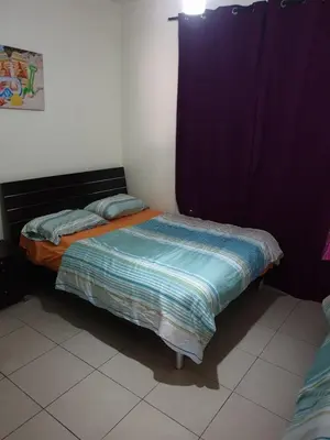 a small bed in a room with a purple curtain at Sea View Apartment at Tala Bay Resort in Aqaba in Aqaba