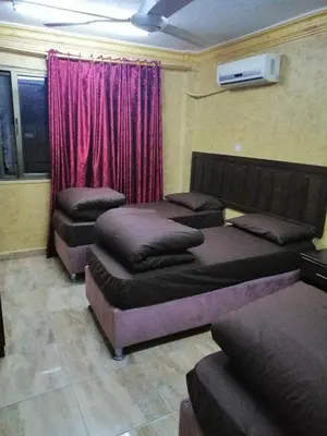 a room with four beds in front of a window at Aqaba Roza in Aqaba