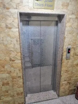 a glass shower door in a stone wall at Aqaba Roza in Aqaba