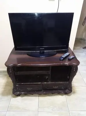 a television sitting on a stand with a remote control at Aqaba Roza in Aqaba