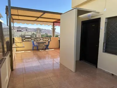 a room with a patio with a table and chairs at Relax House For Studio Rooms Apartments ريلاكس هاوس للشقق المفروشة in Aqaba