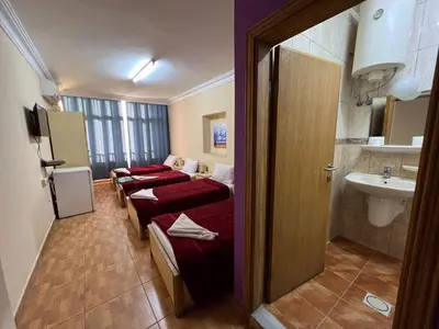 a hotel room with four beds and a sink at Dweik Hotel 1 in Aqaba