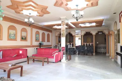 a living room with red couches and a fireplace at Dweik Hotel 1 in Aqaba