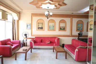 a living room with two red couches and a table at Dweik Hotel 1 in Aqaba