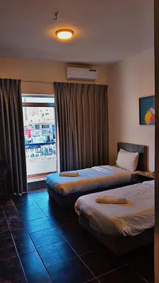 a hotel room with two beds and a window at Hotel magic aqaba in Aqaba