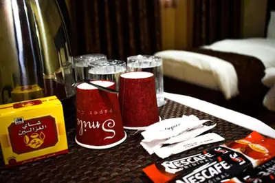 a table in a hotel room with glasses and napkins at Hotel magic aqaba in Aqaba