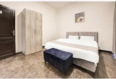 a bedroom with a large bed with a blue stool at Hotel magic aqaba in Aqaba