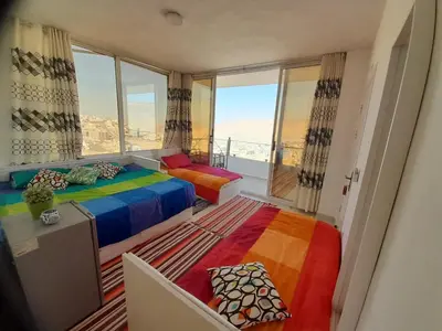 a bedroom with a colorful bed and a large window at Jordan Guest House in Wadi Musa