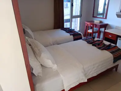 two beds in a room with a mirror at seven7days hotel in Aqaba