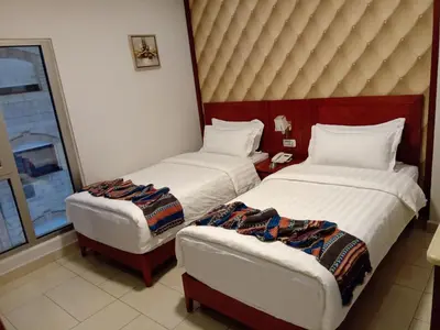 a hotel room with two beds and a chair at seven7days hotel in Aqaba