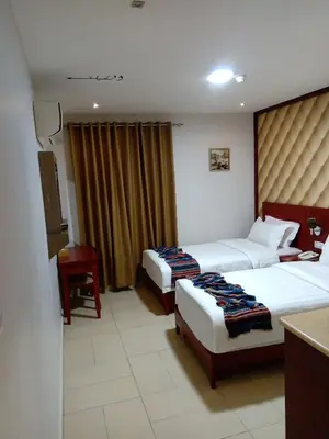 a hotel room with two beds and a desk at seven7days hotel in Aqaba