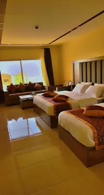 a hotel room with two beds and a couch at Shaqilath Hotel in Wadi Musa