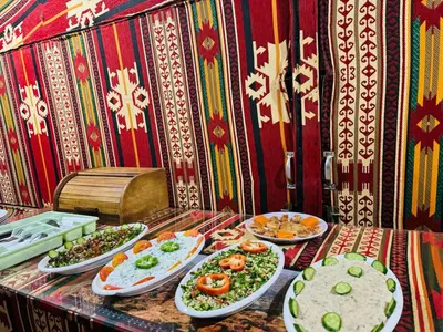 a table with many plates of food on it at Bedouin host camp& with tour in Wadi Rum
