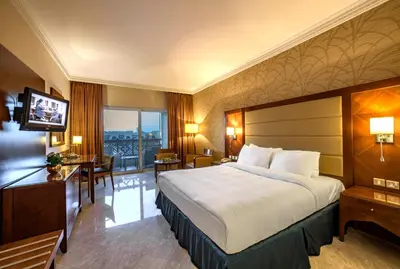 a hotel room with a bed and a desk and a television at Crowne Plaza Jordan Dead Sea Resort & Spa by IHG in Sowayma