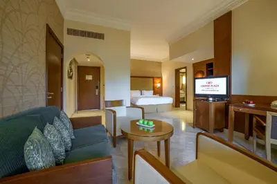 a hotel room with a couch and a bed and a television at Crowne Plaza Jordan Dead Sea Resort & Spa by IHG in Sowayma