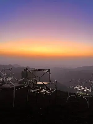 two beds sitting on top of a mountain at sunset at Jabal Dana Hotel - the highest hotel in Jordan in Dana