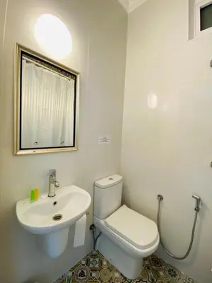 a white bathroom with a toilet and a sink at Arabesque Hotel in Amman