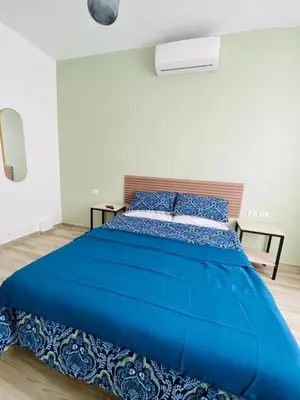 a large blue bed in a white room at Arabesque Hotel in Amman