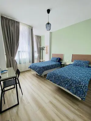 a hotel room with two beds and a table and a desk at Arabesque Hotel in Amman