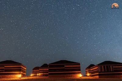 a kite flying in the night sky over buildings at Wadi Rum Magic Nature Camp in Wadi Rum