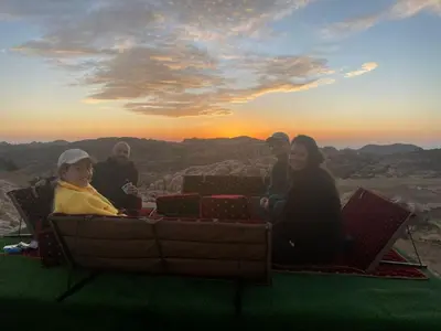 a group of people sitting on top of a mountain at Petra Wassaif Camp in Wadi Musa