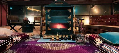 a living room with a fireplace in the middle of a room at Petra Wassaif Camp in Wadi Musa