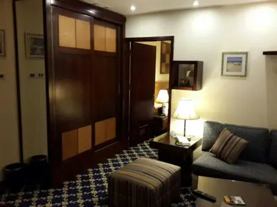 a living room with a couch and a chair and a door at Al Thuraya Hotel in Amman