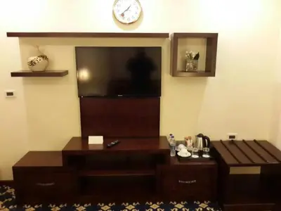 a living room with a flat screen tv on the wall at Al Thuraya Hotel in Amman