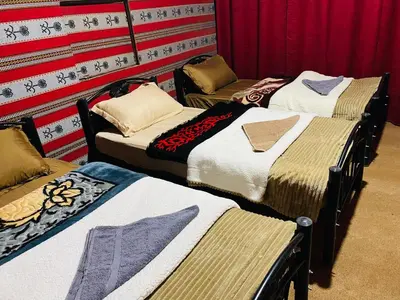 a group of three beds in a room at Desert Tree camp&tours in Wadi Rum