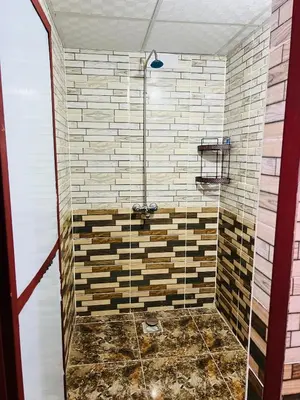 a bathroom with a shower with wooden tiles at Desert Tree camp&tours in Wadi Rum