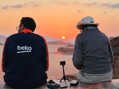 two men sitting on the beach watching the sunset at Desert Tree camp&tours in Wadi Rum